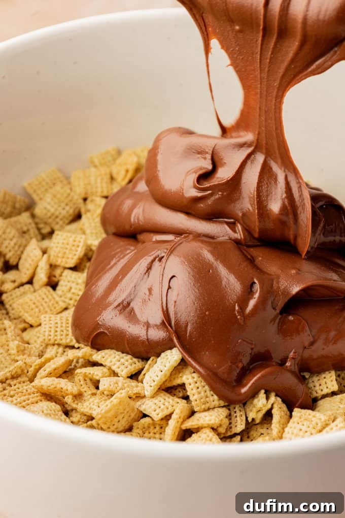 a melted chocolate peanut butter mixture being poured over chex cereal in a white bowl