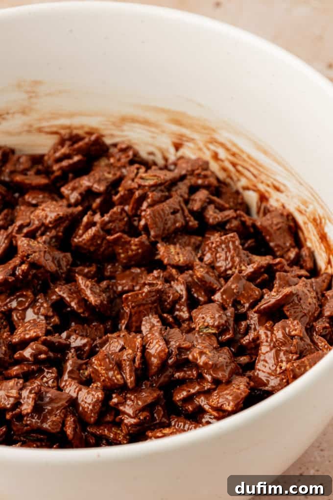 chex cereal coated in a melted chocolate mixture in a white bowl