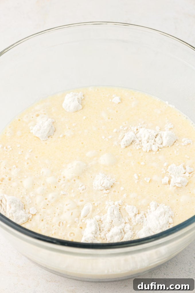 ingredients for sheet pan pancake batter in a clear glass bowl on a white surface