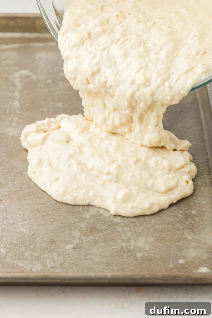 pancake batter being poured into a sheet pan