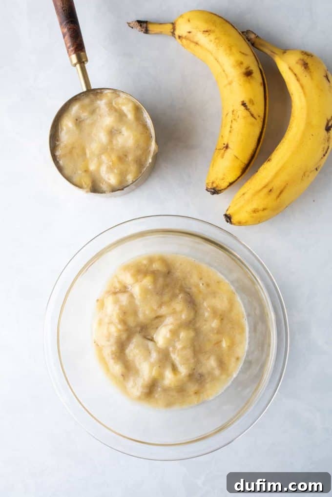 Two cups of perfectly mashed bananas in a measuring cup, ready for the muffin batter.