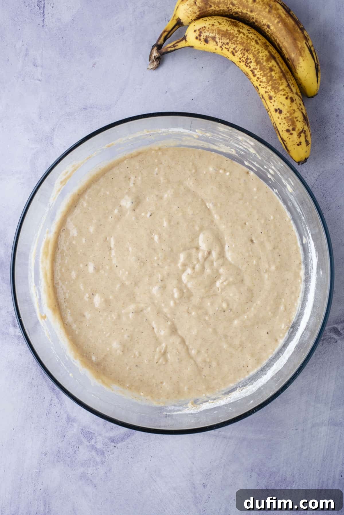 Thick, perfectly mixed healthy banana muffin batter in a mixing bowl, ready for resting.