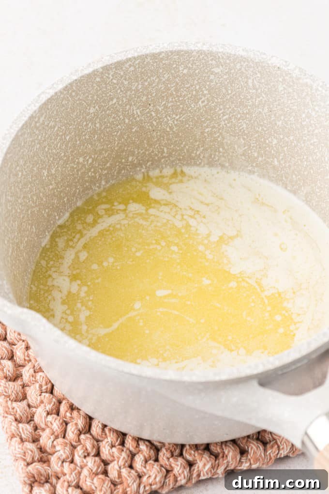 Unlock the Secret to Perfect Chex Mix 5 A small pot sitting on a knit pot holder with freshly melted butter, ready for the seasoning.