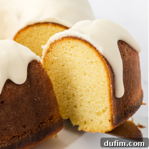 a slice of vanilla bundt cake being lifted by a spatula away from the rest of the cake