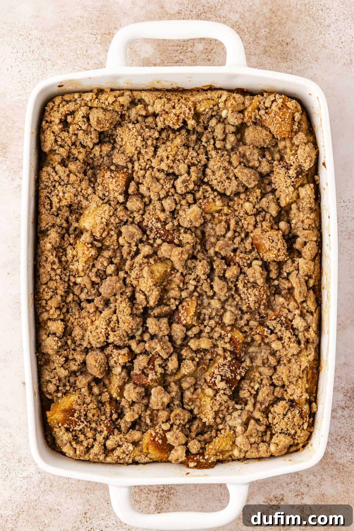 over head view of a white baking dish full of french toast casserole topped with crumb topping