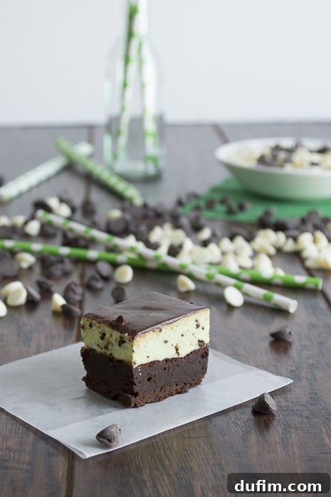 Several Mint Chip Mousse Brownies, individually wrapped in foil, are shown ready for freezing. The rich dark chocolate, light green mousse, and glossy topping are visible, highlighting their freezer-friendly nature.