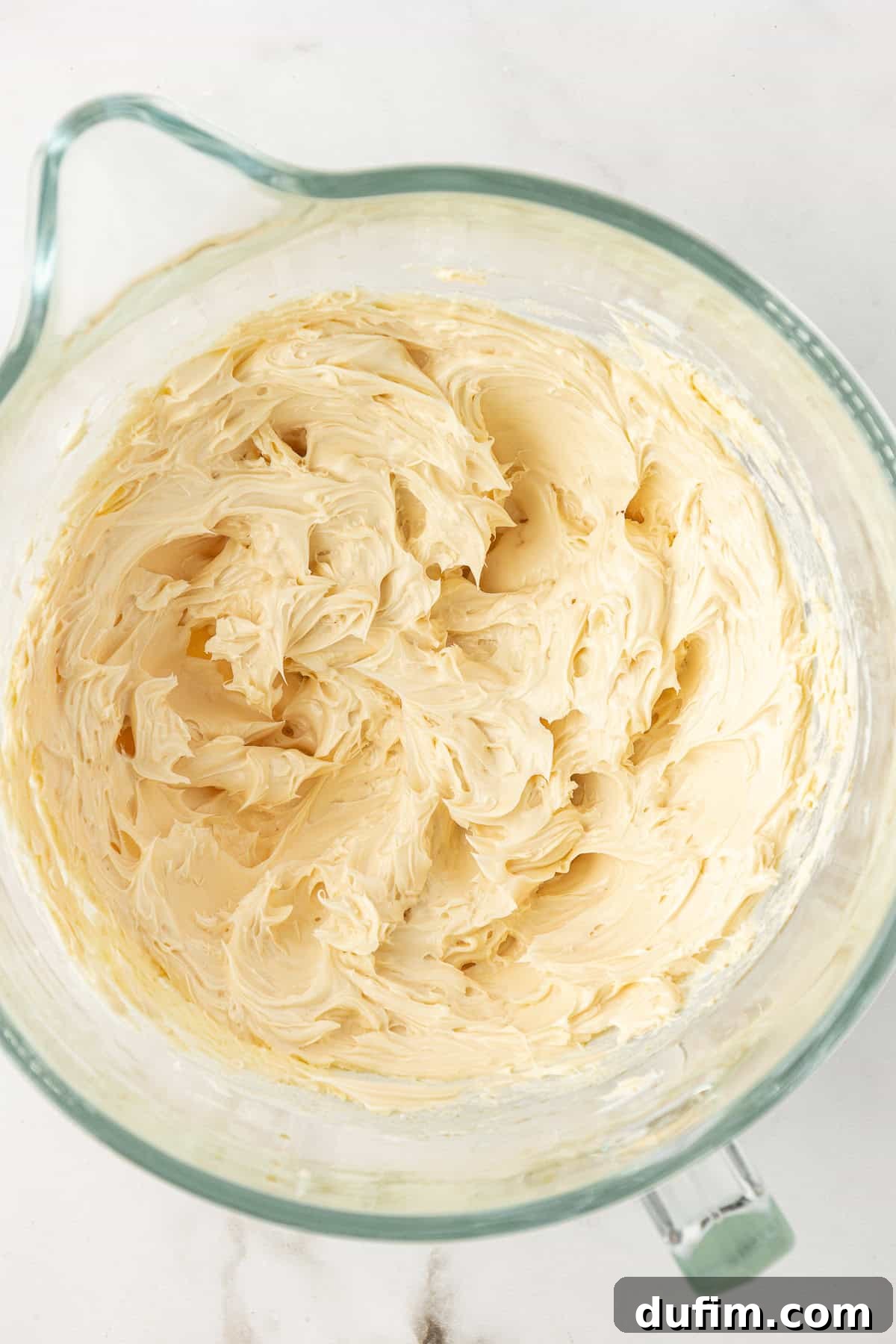 The butter, vanilla extract, and salt mixture, after being beaten to a light and fluffy consistency for the vanilla frosting.