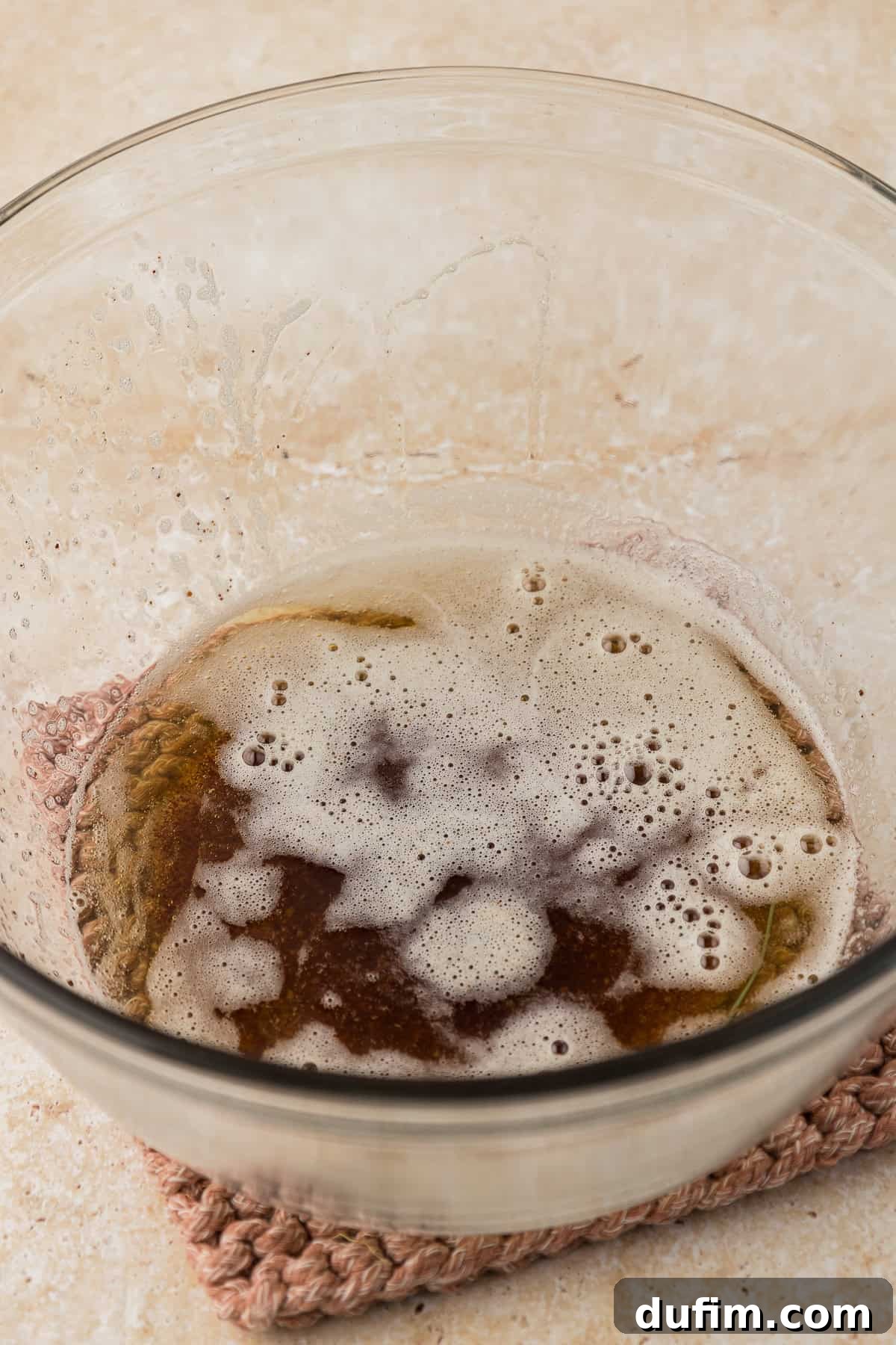 A clear glass bowl showcasing the perfectly melted and browned butter, its rich amber color a testament to its nutty flavor.