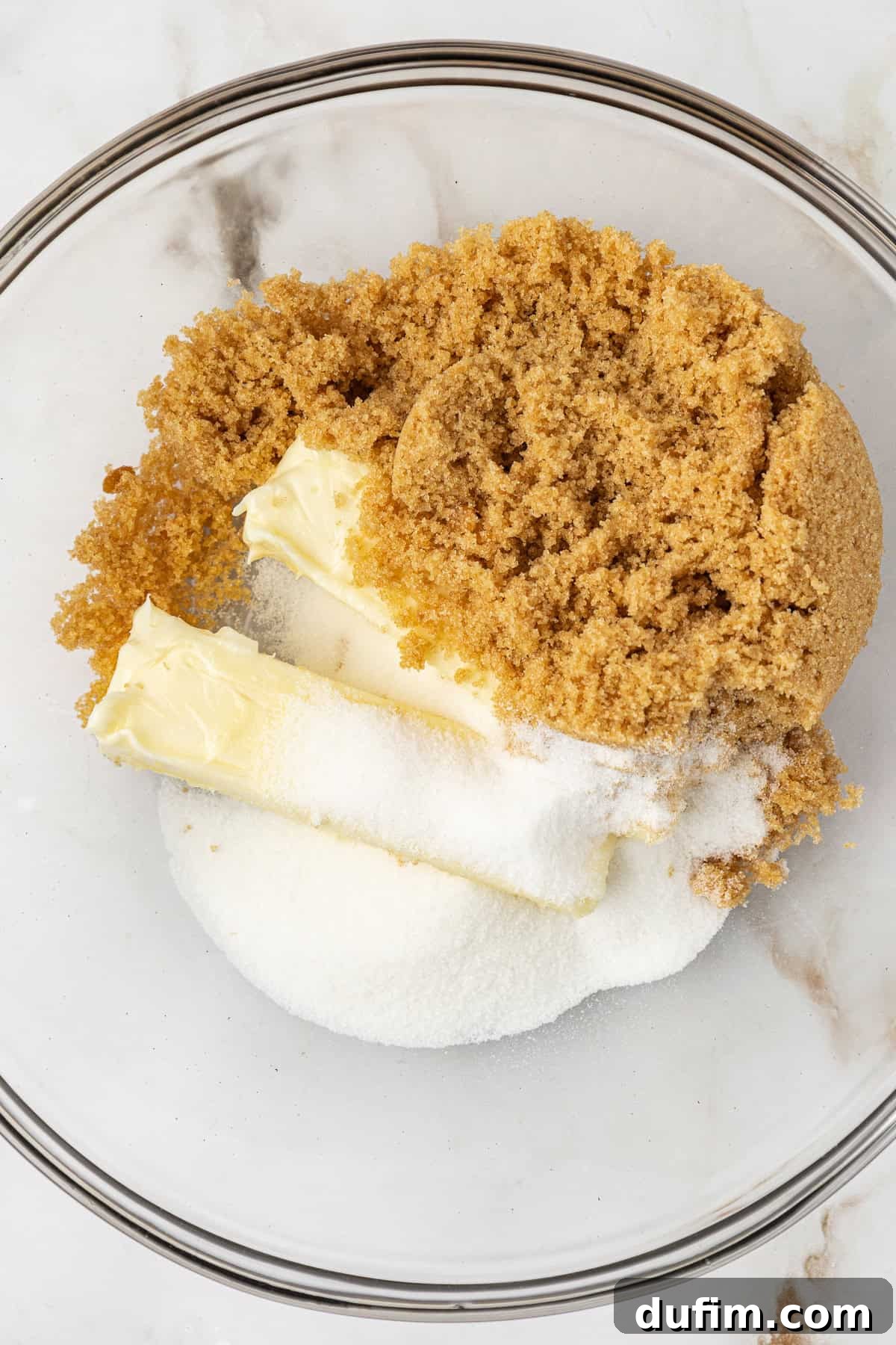 Sweet Butterscotch Chip Delights 7 Unsalted butter, light brown sugar, and granulated sugar ready to be creamed in a clear glass bowl.