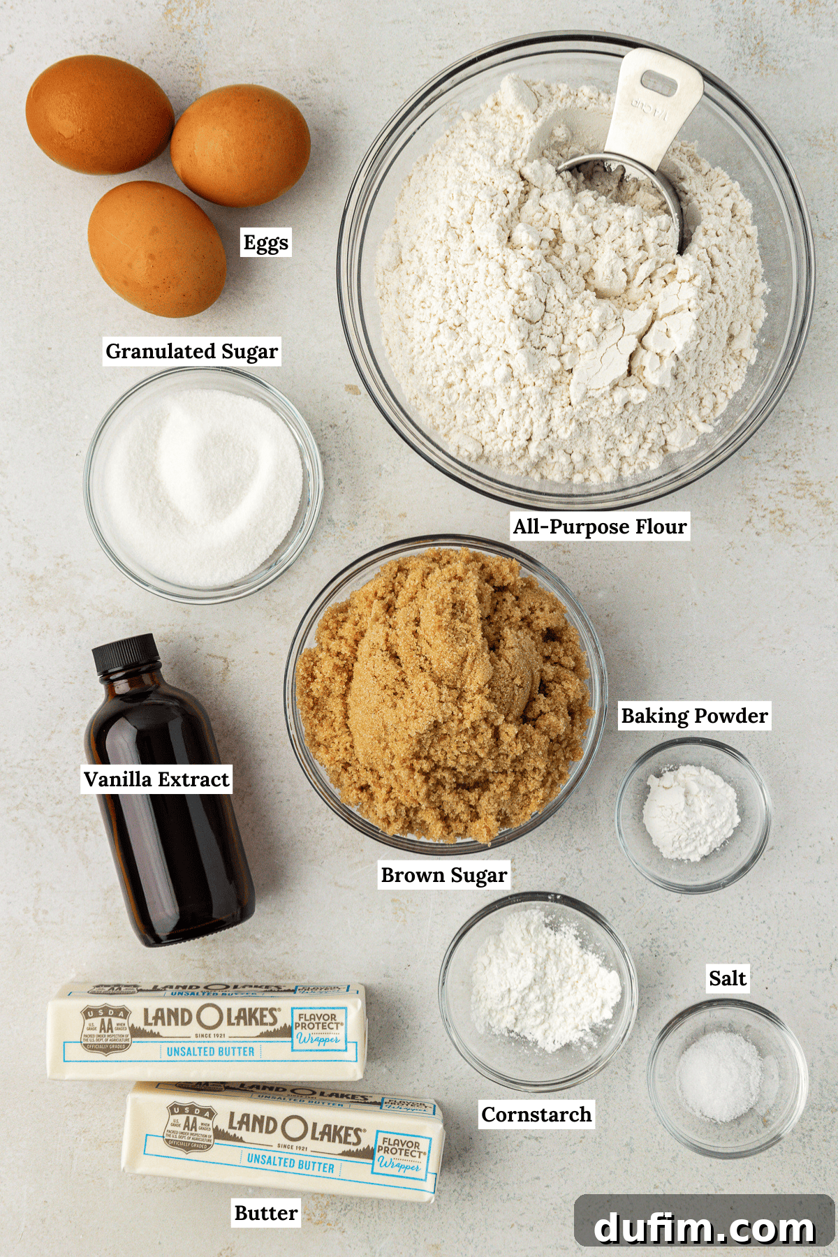 Golden Blondie Bars 6 An overhead view of all the essential ingredients for blondies, neatly arranged: eggs, all-purpose flour, granulated sugar, brown sugar, vanilla extract, baking powder, cornstarch, butter, and salt.