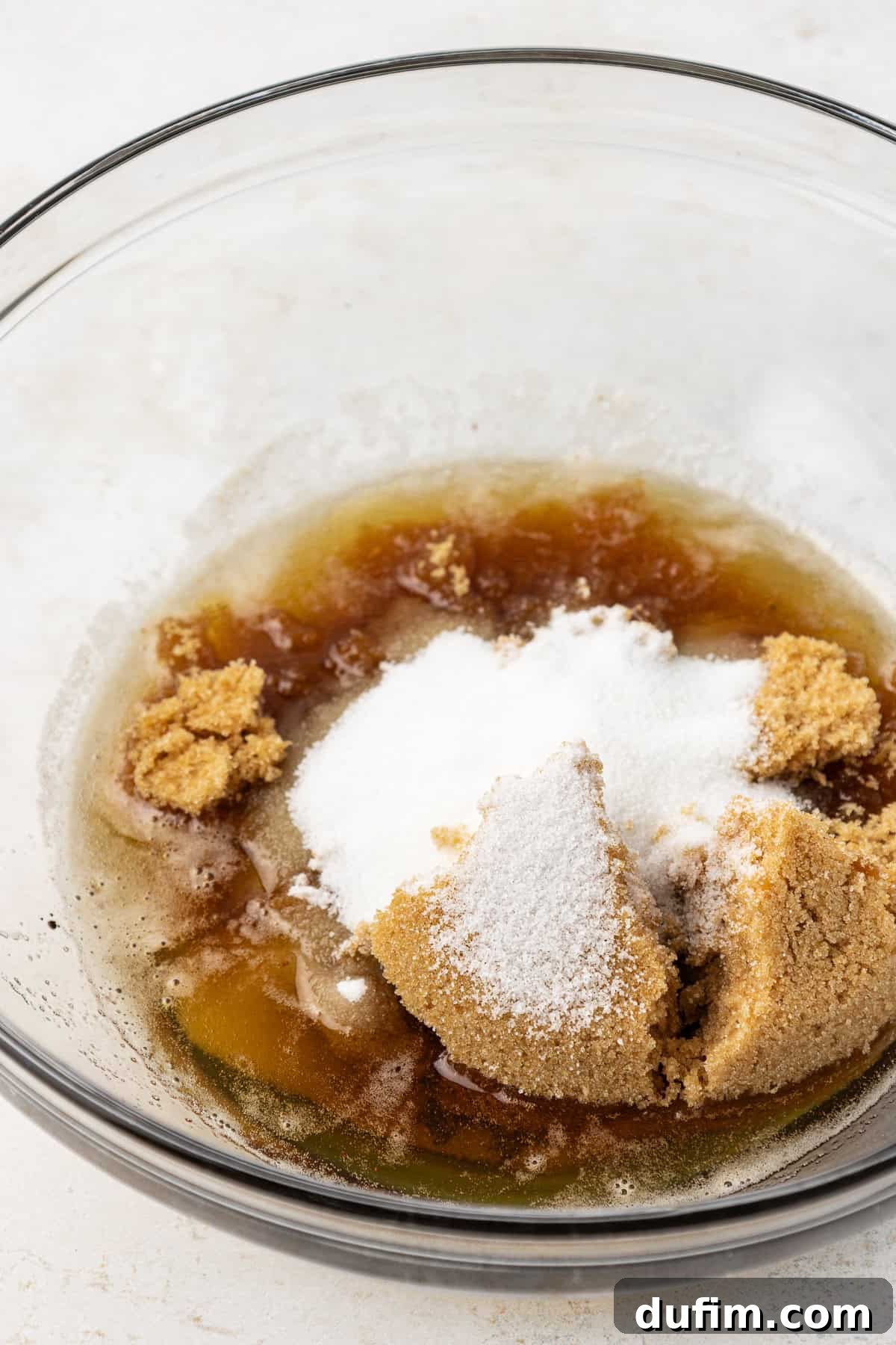 Golden Blondie Bars 9 Granulated sugar, brown sugar, and eggs neatly arranged in a clear glass mixing bowl, awaiting the next step in the blondie preparation.