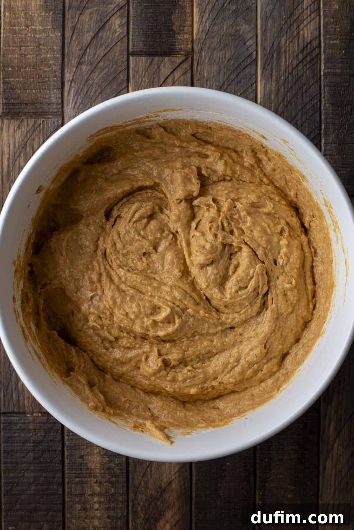 pumpkin muffin batter mixed in a large white bowl