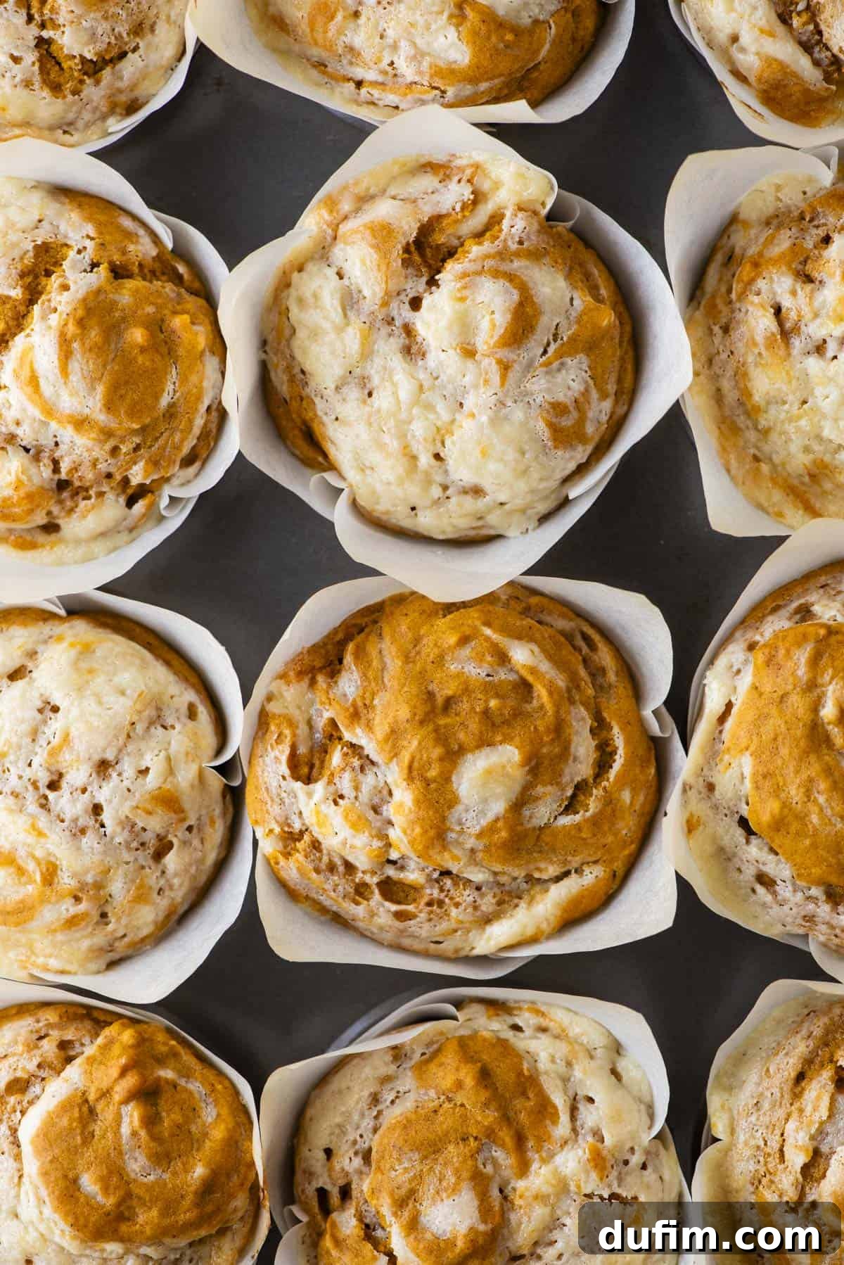 over head close up view of the tops of rows of pumpkin cream cheese muffins