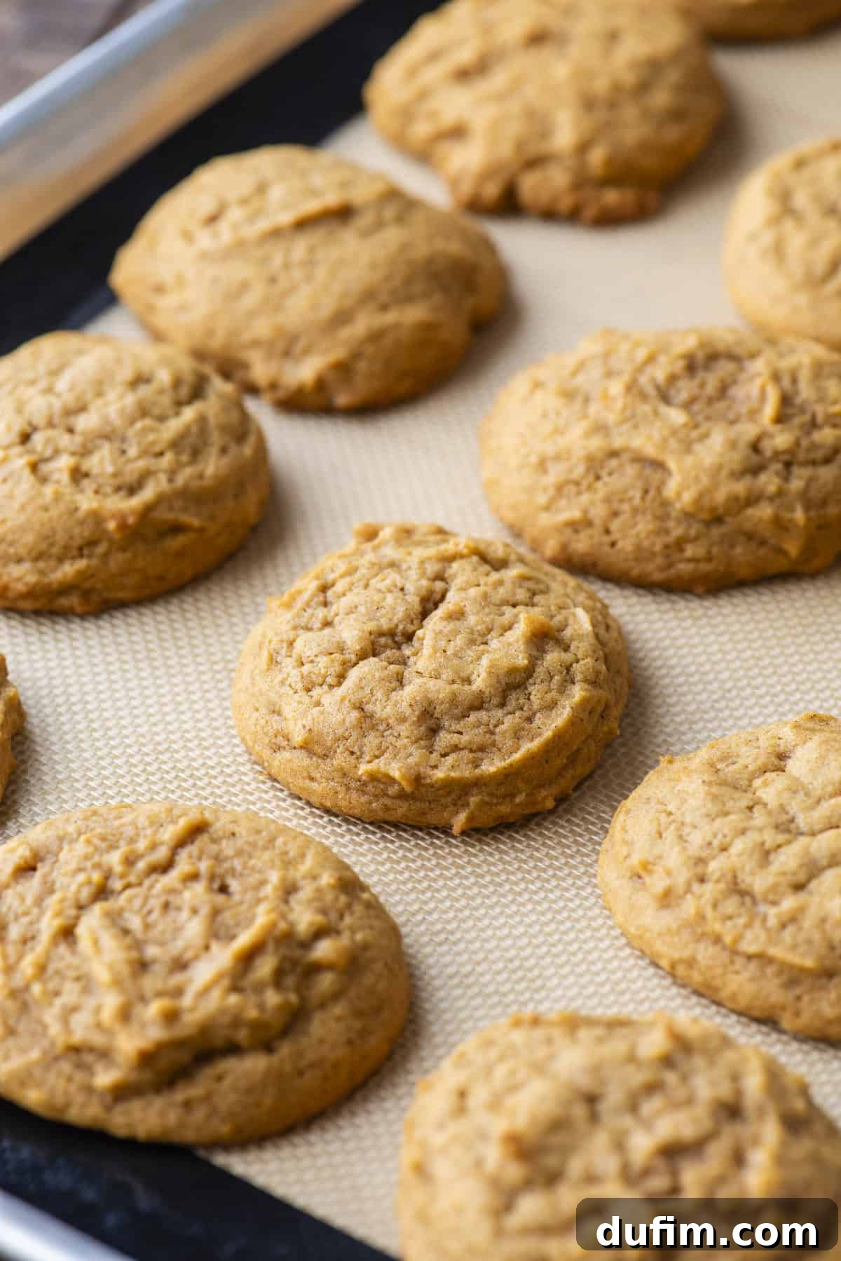 Cozy Autumn Pumpkin Spice Cookies 13 rows of freshly baked pumpkin cookies on a baking sheet lined with a silicone baking mat