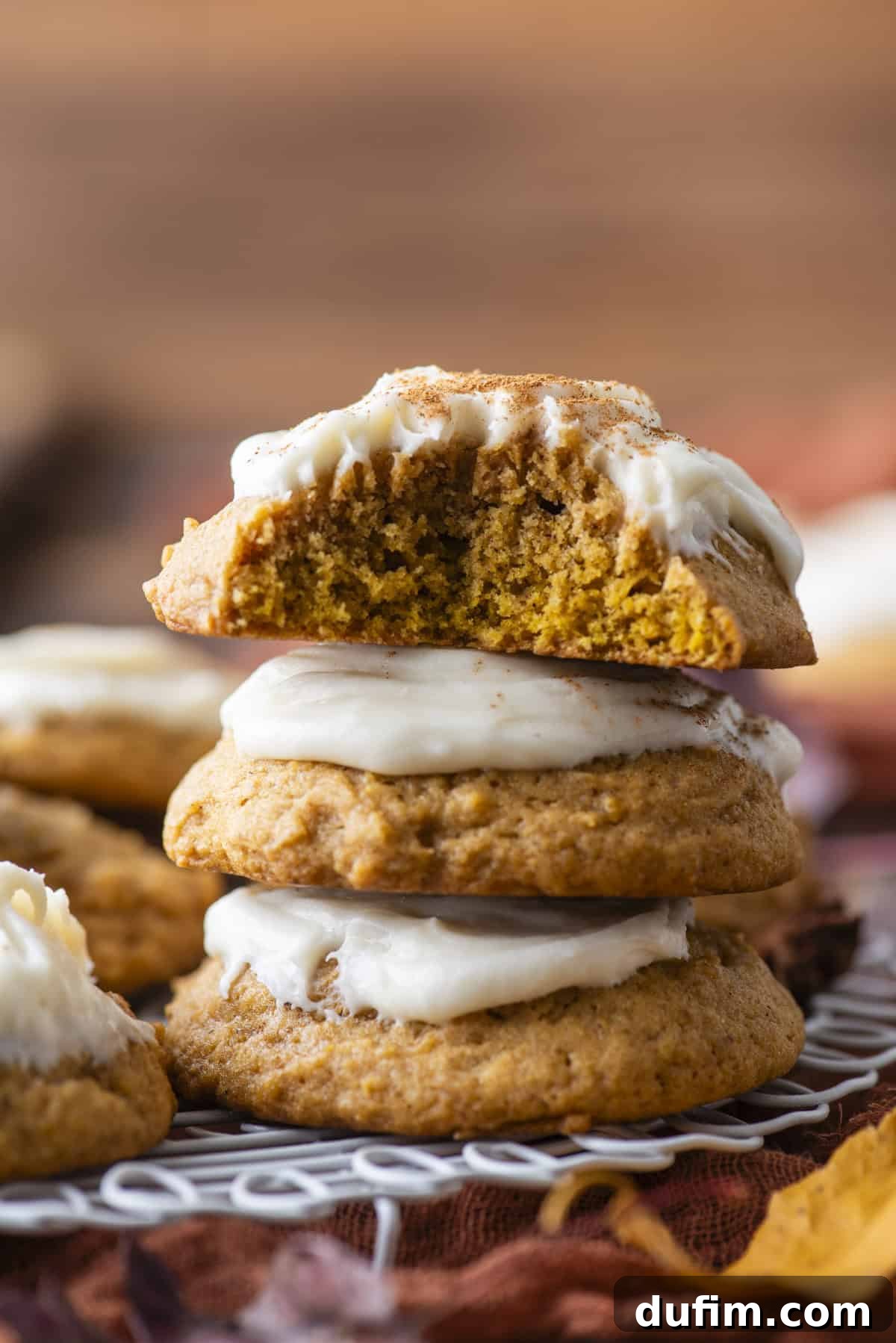Cozy Autumn Pumpkin Spice Cookies 17 three pumpkin cookies stacked with a bite missing out of the top cookie