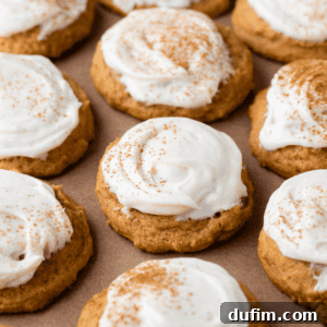 rows of pumpkin cookies with cream cheese frosting