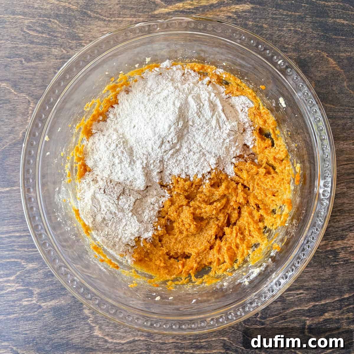 Cozy Autumn Pumpkin Spice Cookies 10 pumpkin cookie dough ingredients in a clear glass bowl, with flour mixture not yet mixed in
