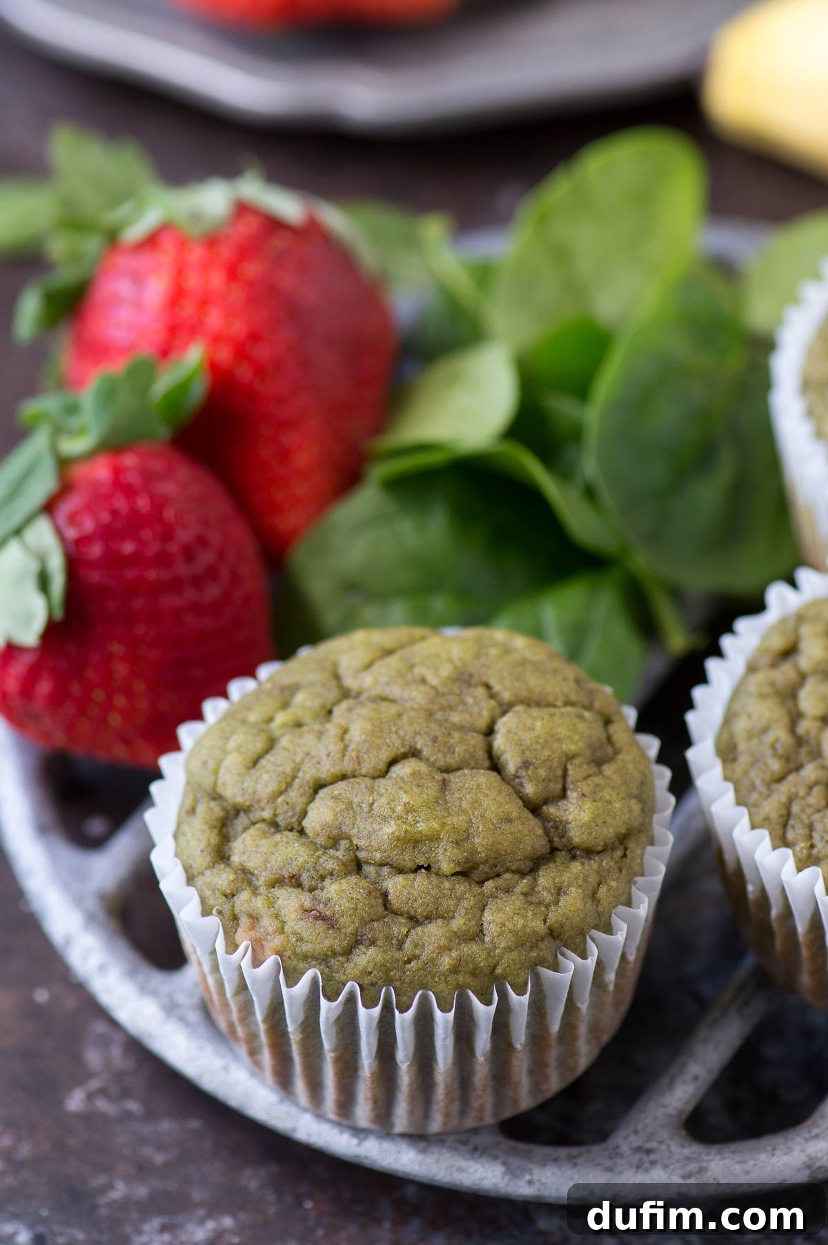 Freshly baked green spinach muffins cooling on a metal wire rack.