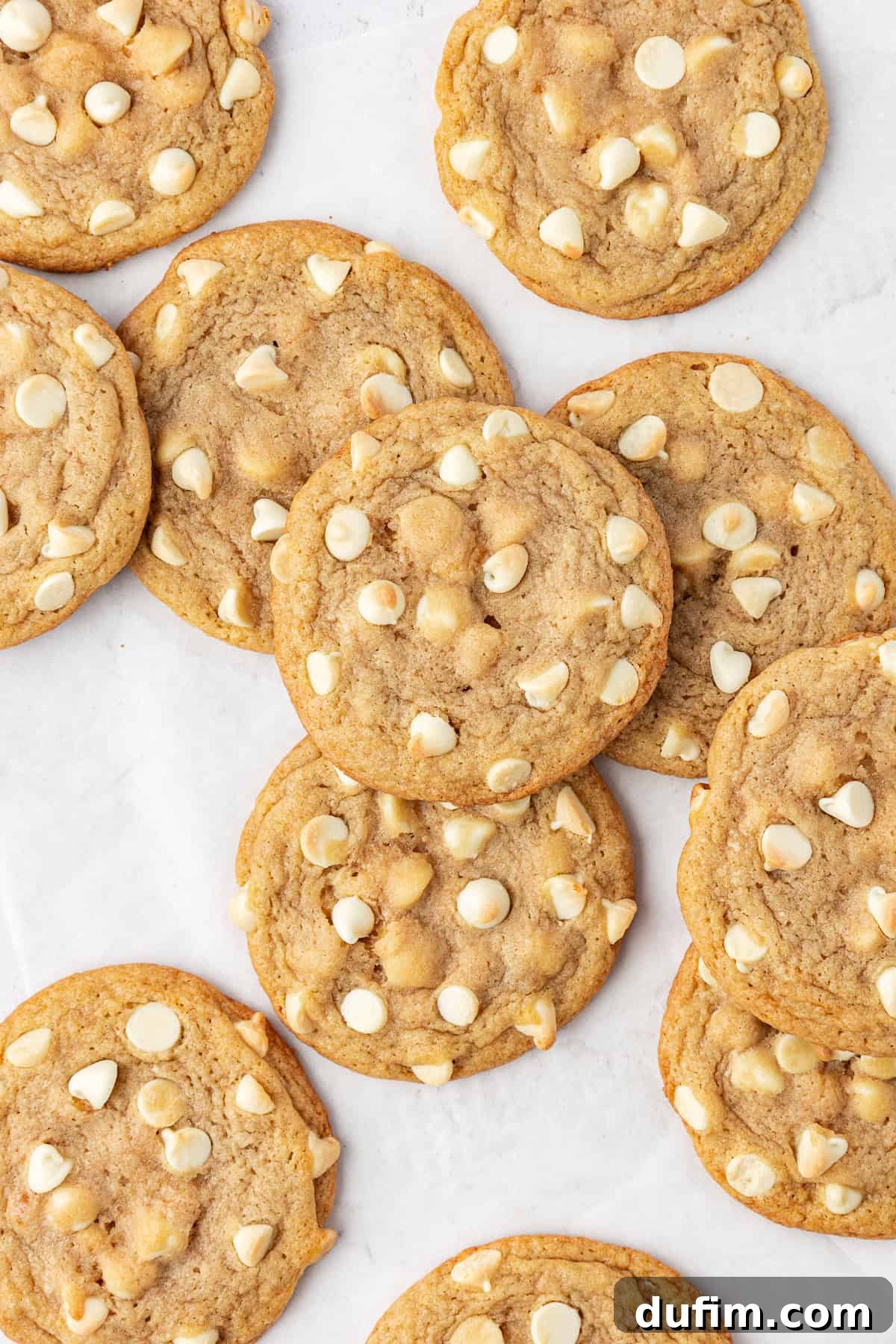 Overhead view of scattered white chocolate chip cookies