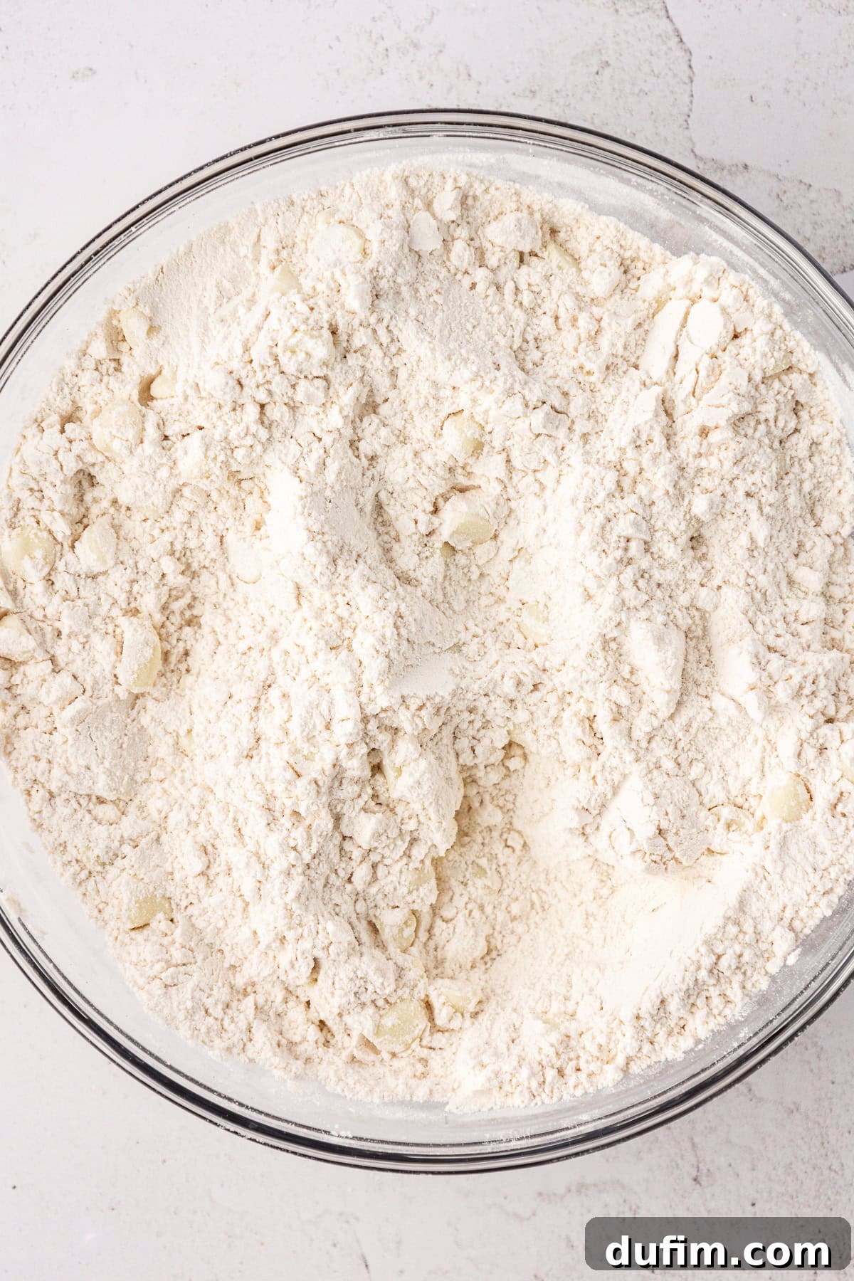 Flour mixture for white chocolate chip cookies in a large glass bowl
