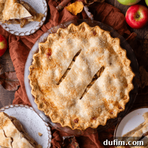 An inviting overhead view of a freshly baked apple pie, surrounded by individual slices on small plates, showcasing its golden crust and delicious filling, ready to be enjoyed.