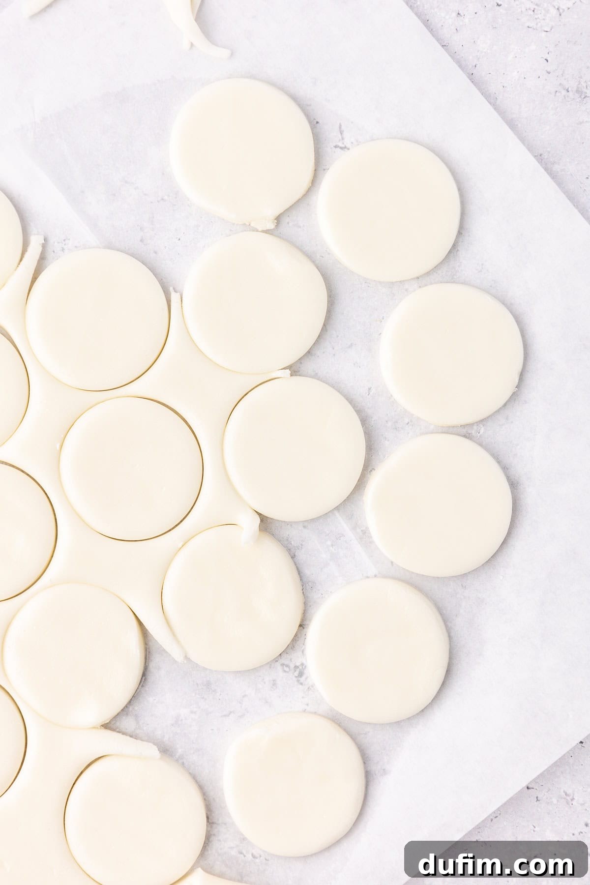 Cool & Creamy Homemade Peppermint Patties 11 Neatly arranged round discs of peppermint patty filling, freshly cut and ready for chilling on white parchment paper.