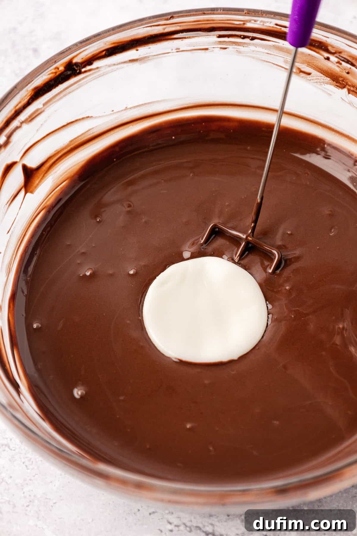 Cool & Creamy Homemade Peppermint Patties 12 A pristine white disc of chilled peppermint patty filling being gently immersed into a clear glass bowl filled with luscious melted chocolate.