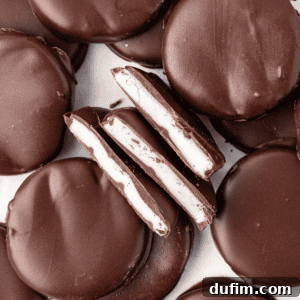 Cool & Creamy Homemade Peppermint Patties 17 A beautiful stack of homemade peppermint patties, with some cut in half to show the creamy white filling.