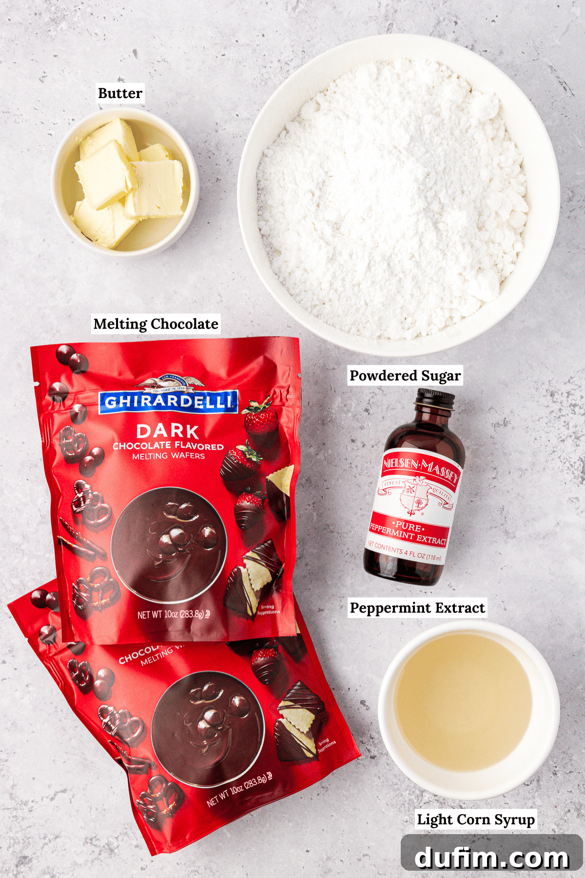 Cool & Creamy Homemade Peppermint Patties 4 An overhead view showcasing all the simple ingredients required for homemade peppermint patties, neatly arranged: sticks of butter, a bowl of powdered sugar, Ghirardelli chocolate melting wafers, peppermint extract, and a bottle of light corn syrup.