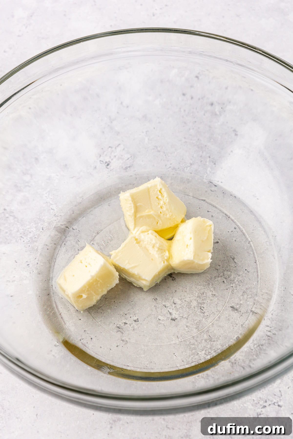 Cool & Creamy Homemade Peppermint Patties 6 Cubes of softened unsalted butter in a clear glass mixing bowl, ready for the first step of the recipe.