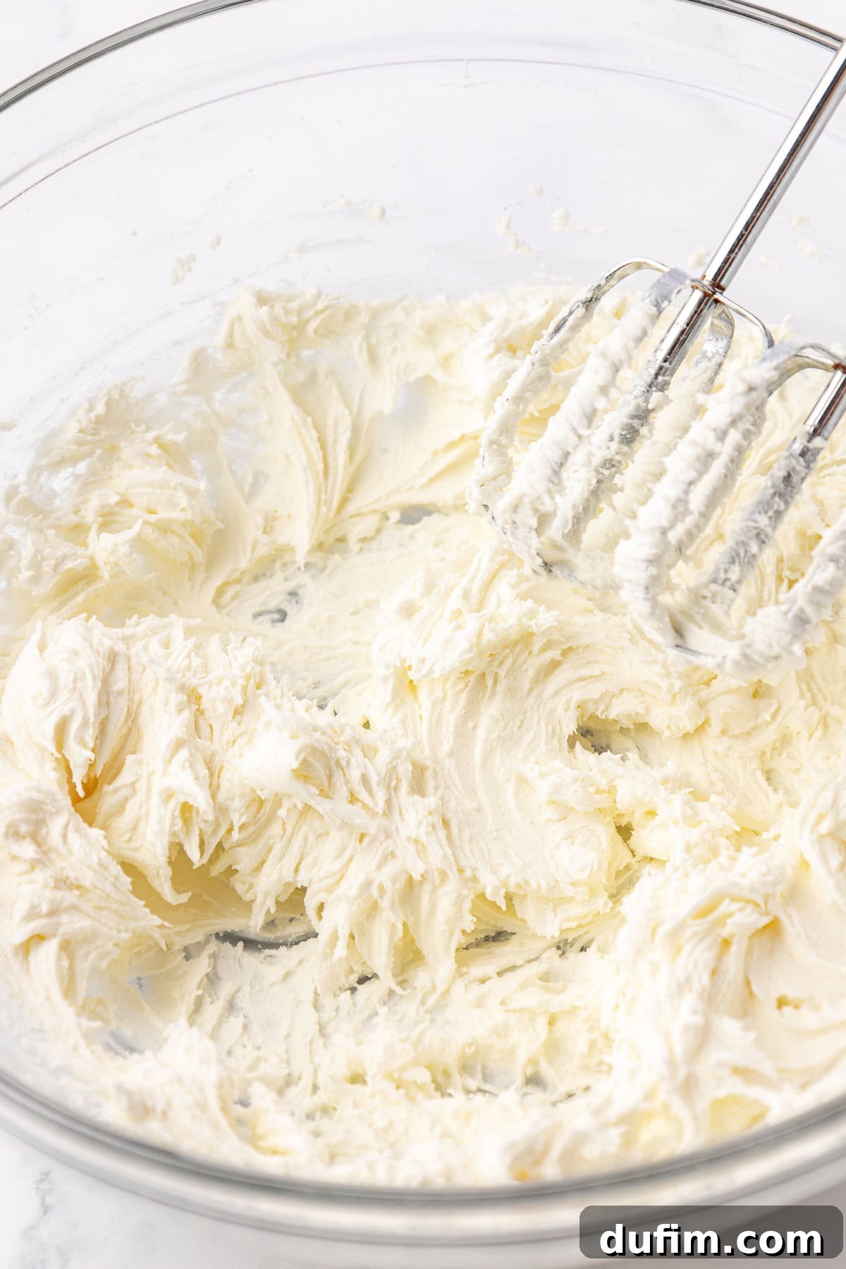 Melt-In-Your-Mouth Butter Mints 10 The butter and powdered sugar for butter mints being gently mixed in a clear glass bowl with an electric mixer on low speed.