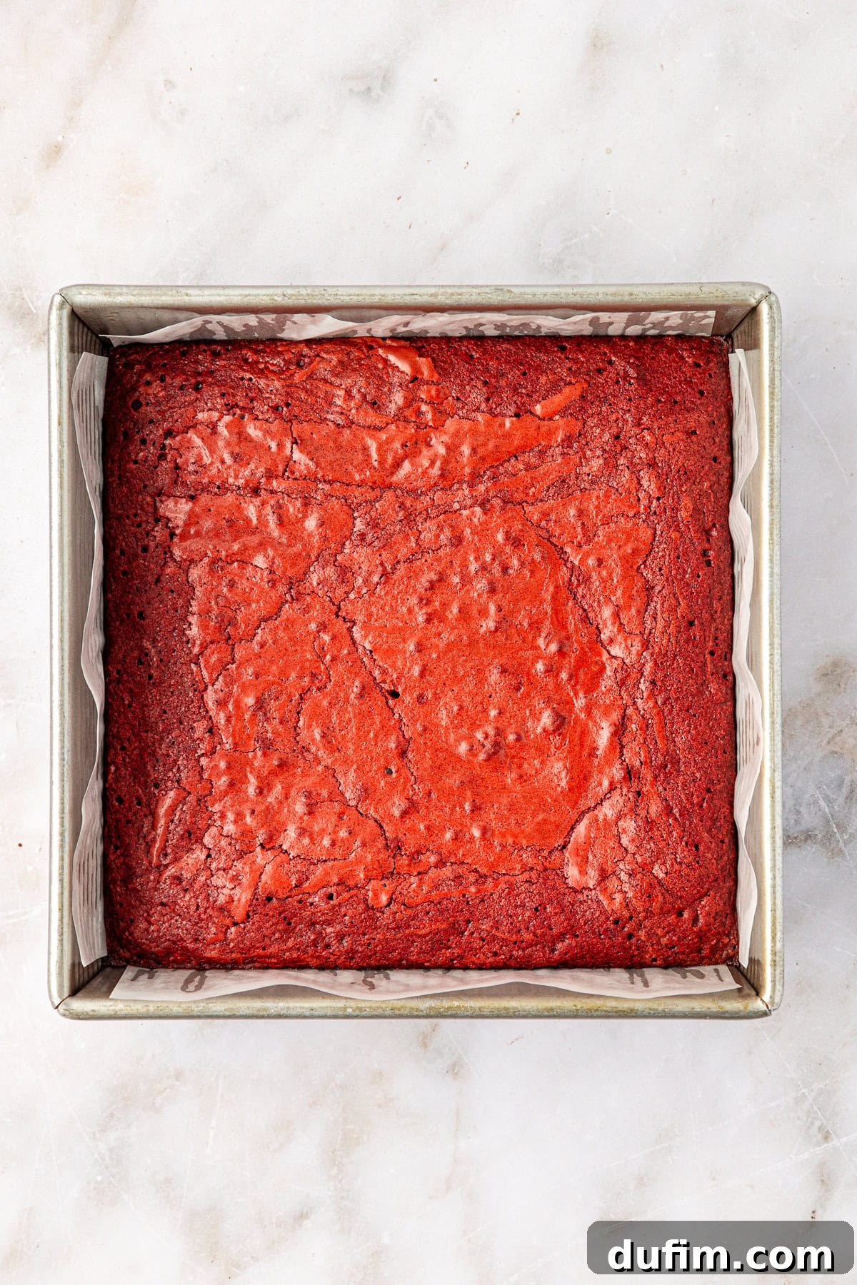 overhead view of a square baking pan full of freshly baked red velvet brownies