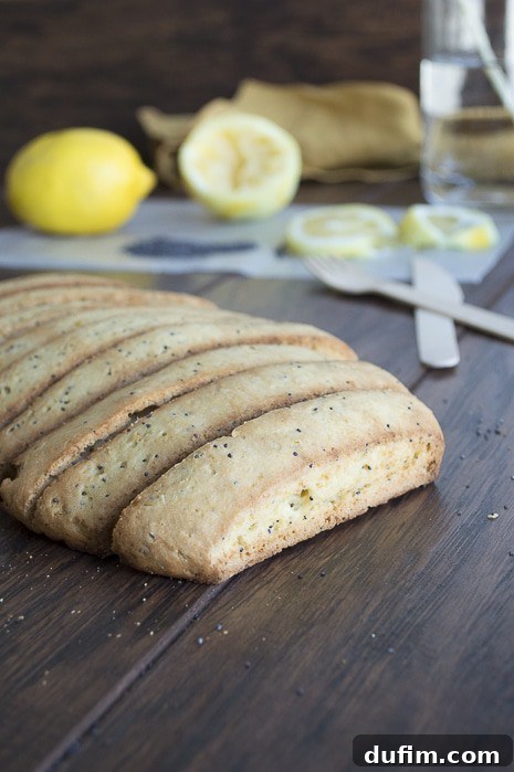 Close-up of golden-brown lemon poppy seed biscotti with visible poppy seeds.