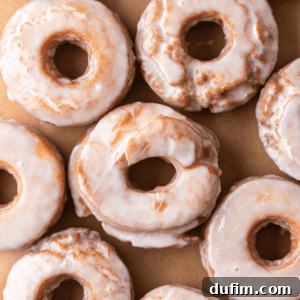 Close up of rows of donuts covered in glossy donut glaze, shining perfectly.