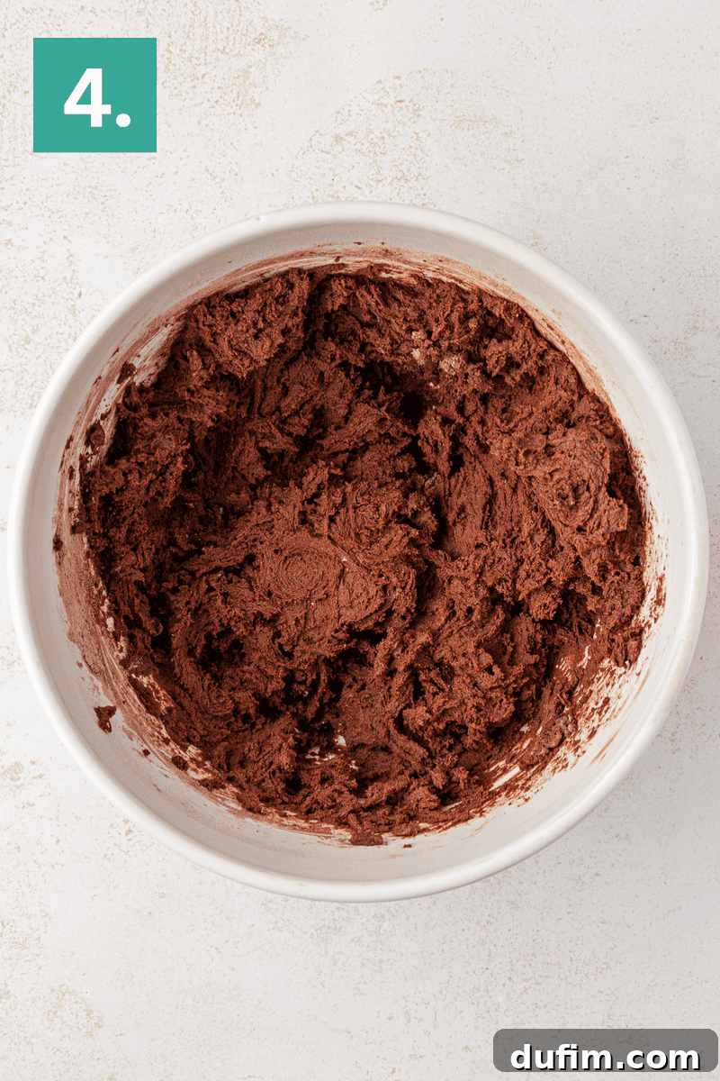 A white mixing bowl is now filled with a rich, dark chocolate cookie dough, beautifully combined, and sitting on a light surface. In the top left corner, a green box with the number 4 marks the recipe step.