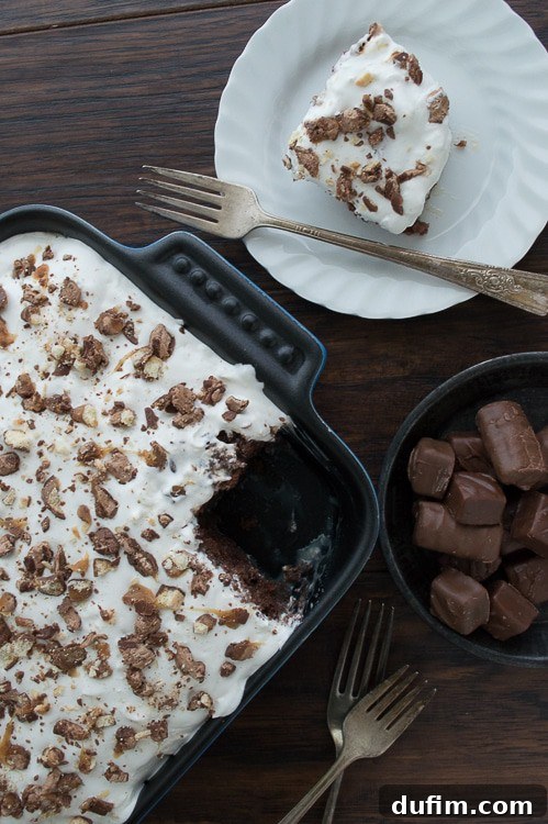 Another perspective of the freshly made Candy Bar Cake, showcasing its delightful topping of chopped candy and chocolate drizzle.