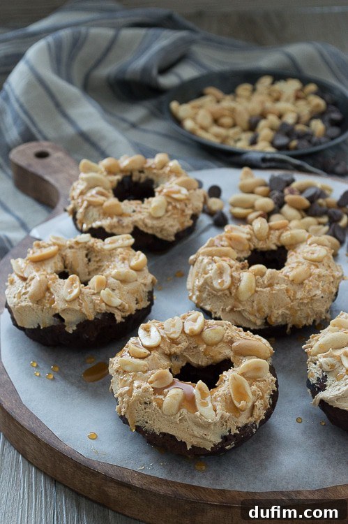 Multiple Snickers Donuts arranged on a wire rack, showcasing their irresistible toppings and ready to be devoured.