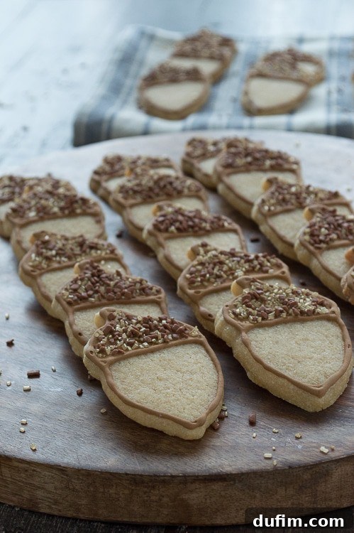 Harvest Maple Acorn Cookies 4 Beautifully decorated maple acorn cookies with brown royal icing caps and golden sprinkles.