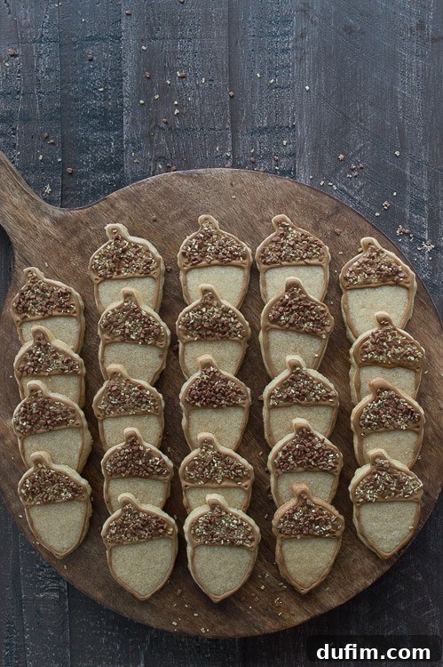 Harvest Maple Acorn Cookies 5 A collection of decorated maple acorn cookies arranged on a plate, ready to be enjoyed.