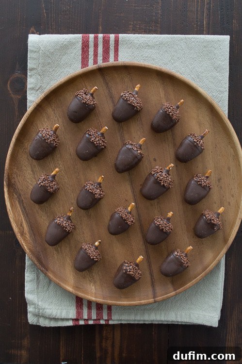 Eighteen EASY Peanut butter oreo balls on a wooden board on top of a white cloth with four thin red stripes, demonstrating their simple elegance.
