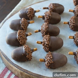 Adorable and delicious oreo acorn ball desserts on a round wooden board.