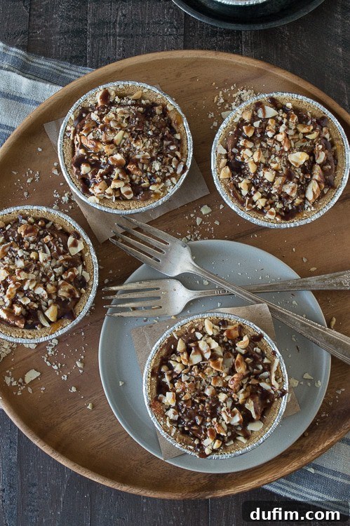 Close-up of a mini no-bake pie, showcasing the creamy chocolate filling and mixed nut topping, beautifully drizzled with chocolate and caramel.