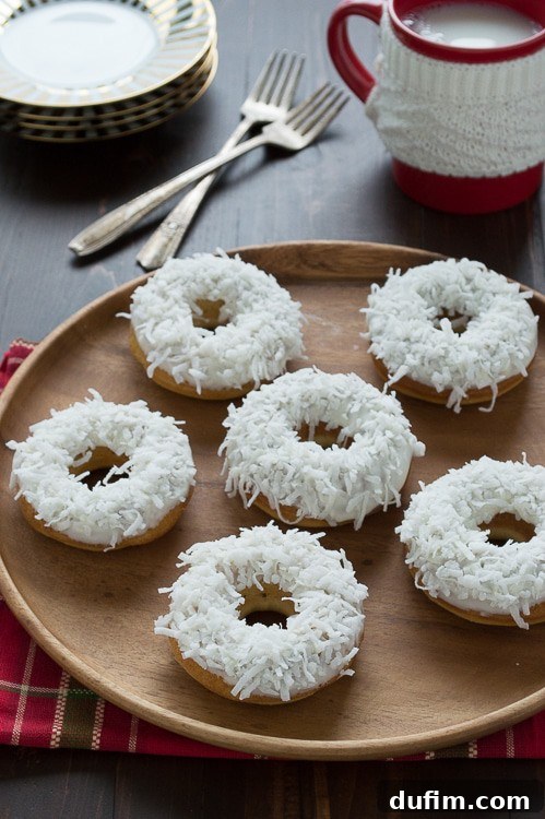 A close-up shot of two caramel coconut snowmen donuts, showing intricate details of their faces.