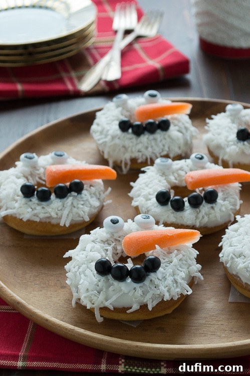 A beautifully arranged plate of caramel coconut snowmen donuts, perfect for gifting or serving at a holiday brunch.