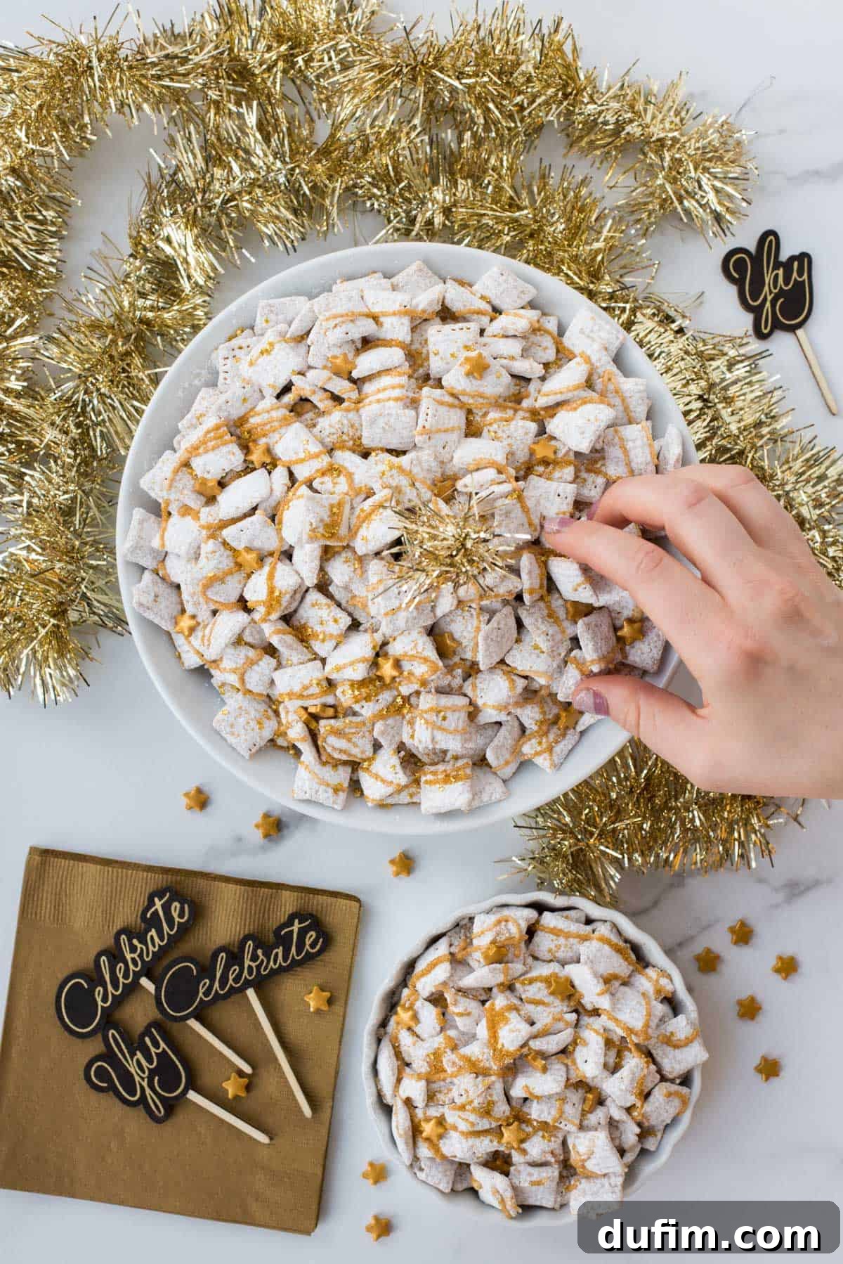 Sparkling White Chocolate New Year's Chow 3 Brightly lit New Year's Eve white chocolate puppy chow, garnished with gold sprinkles and shiny gold stars, presented on a clean white background.