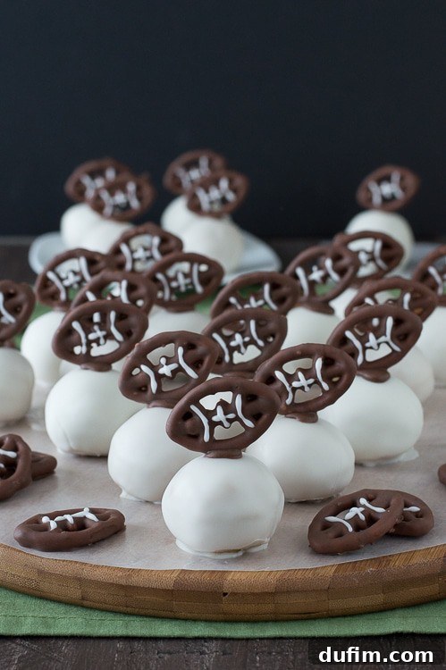 Football Oreo Balls - golden oreo balls dipped in white chocolate and topped with football pretzels! Make these for game day!