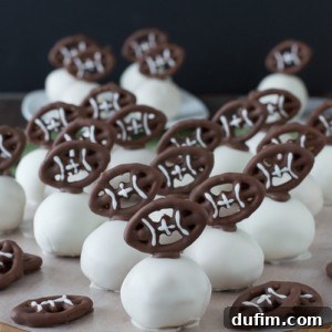 Football Oreo Balls - golden oreo balls dipped in white chocolate and topped with football pretzels! Make these for game day!