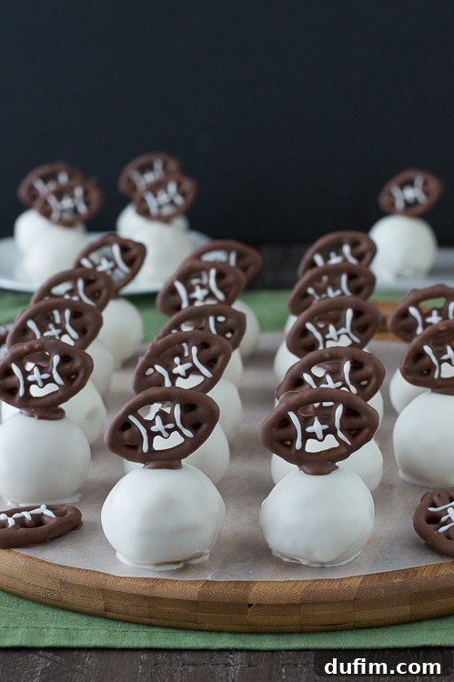 Football Oreo Balls - golden oreo balls dipped in white chocolate and topped with football pretzels! Make these for game day!
