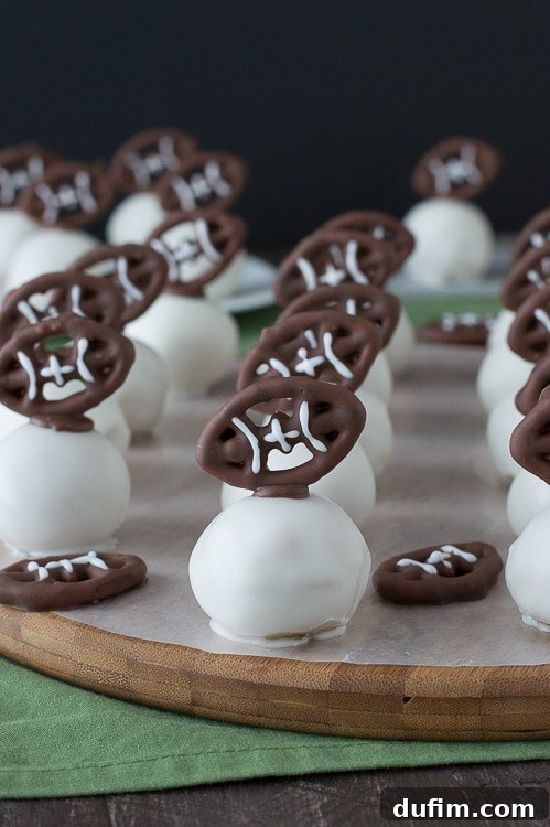 Football Oreo Balls - golden oreo balls dipped in white chocolate and topped with football pretzels! Make these for game day!