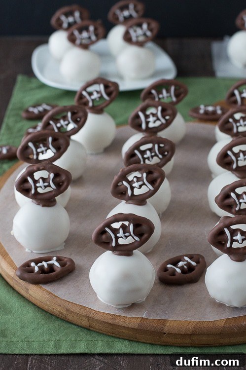 Football Oreo Balls - golden oreo balls dipped in white chocolate and topped with football pretzels! Make these for game day!